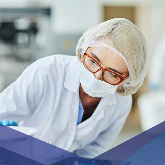 마스크, 헤어 커버, 안경을 착용하고 임상 또는 멸균 환경에서 작업하는 실험실 기술자.